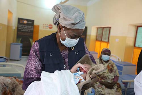 Executive Director Dr. Natalia Kanem holds a newborn baby in the Damazin maternity hospital.