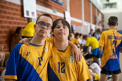 Two young men with disabilities are pictured participating in a sports activity.