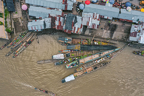 Boats are seen on a river, photographed from above.