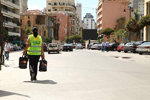 A field worker carries dignity kits through the streets of Beirut.