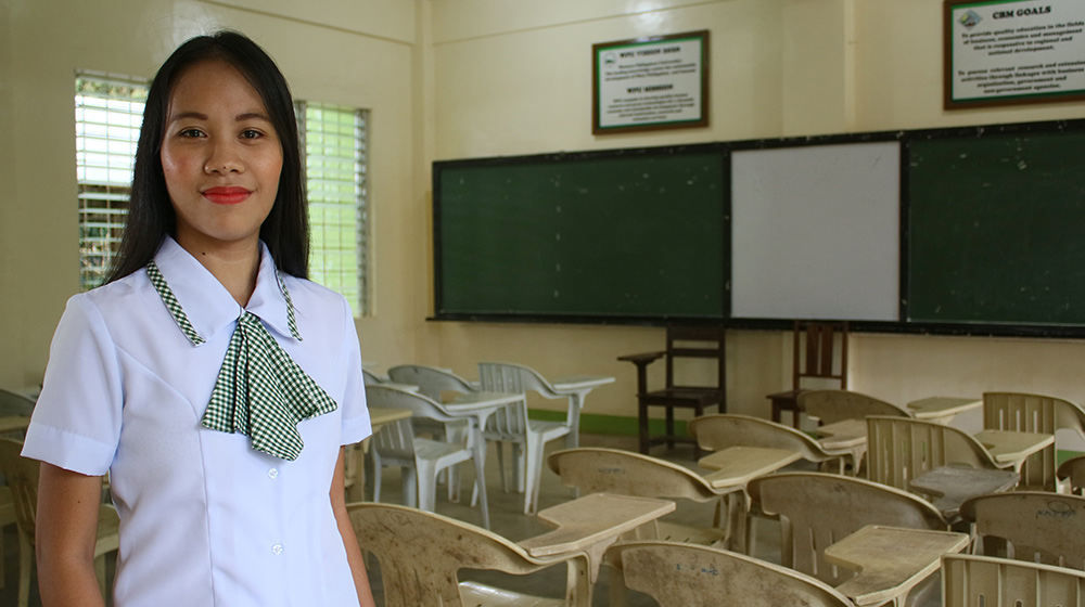 Shaina, a girls' advocate in the Philippines, stands in an empty classroom. 