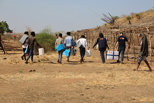 People carry UNFPA-provided supplies through Um Raquba.