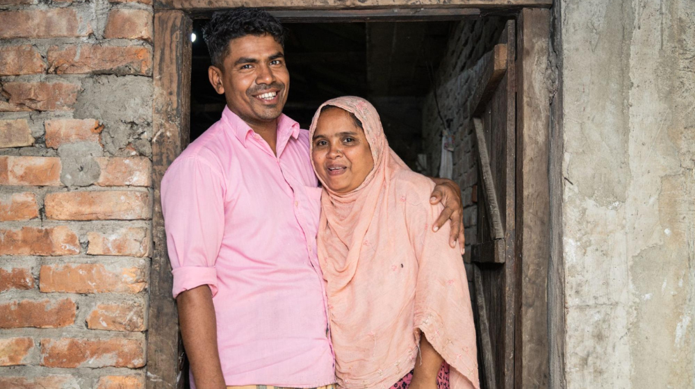  A man stands with his arm around a woman.