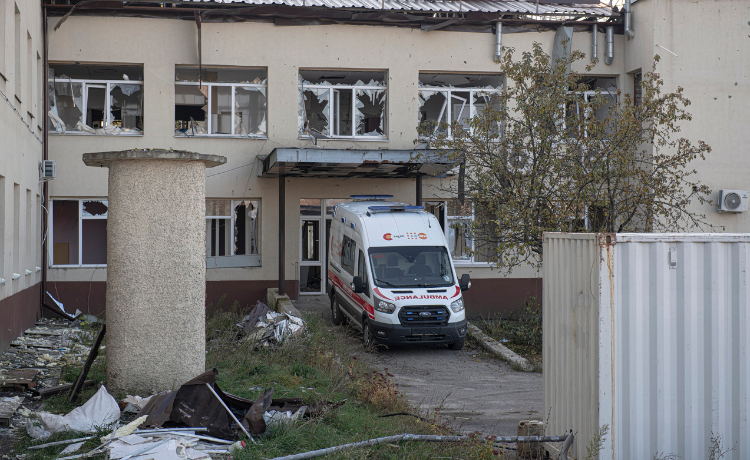 Une ambulance devant un bâtiment endommagé