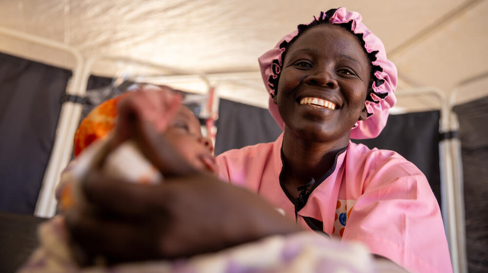 UNFPA midwife Lucille Denembaye holds an 11-day-old boy she delivered in a camp for displaced people in the Toukra district of N’Djamena in Chad. © UNFPA Chad/Karel Prinsloo