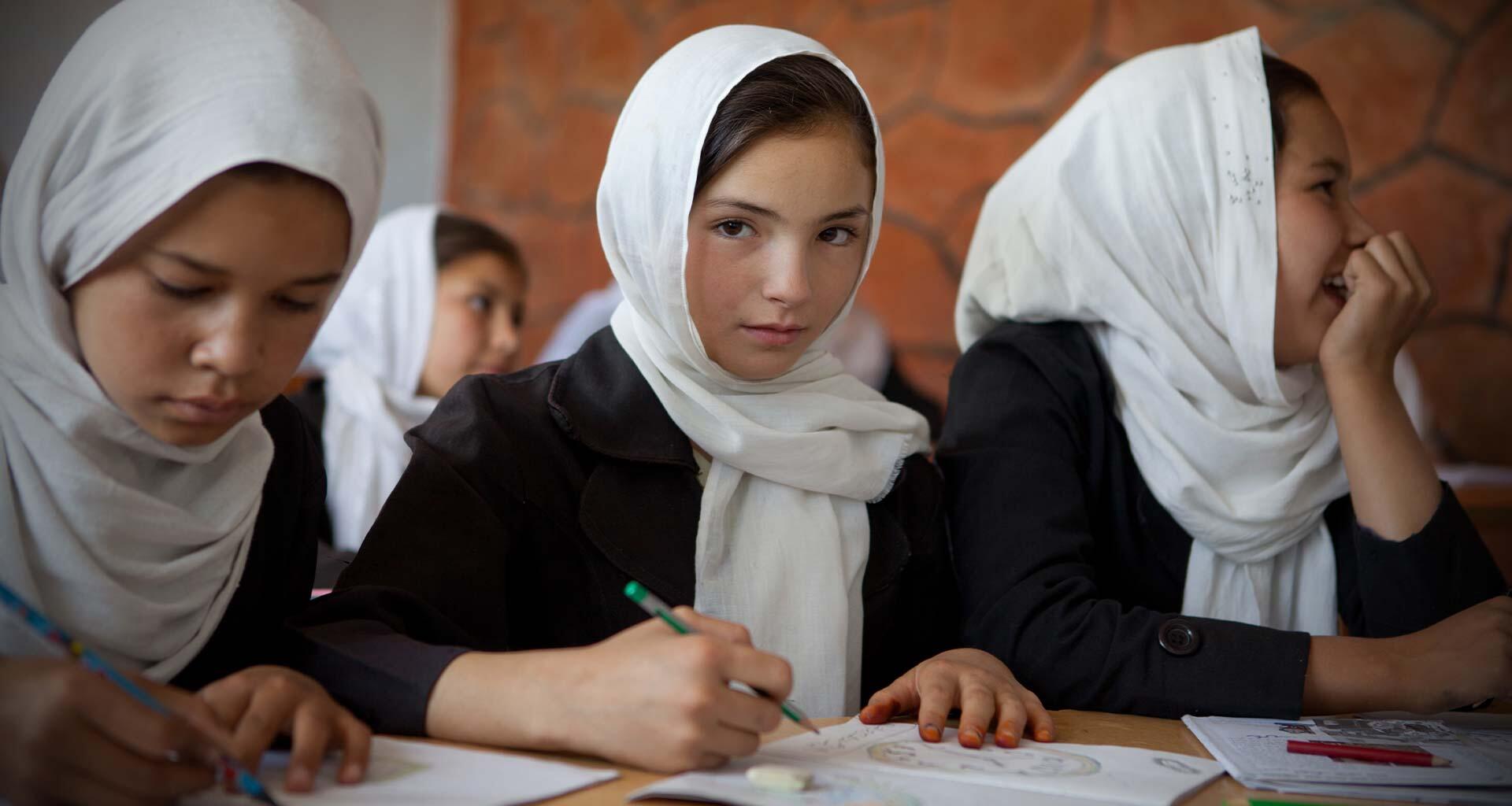 A young girl sits with her classmates.