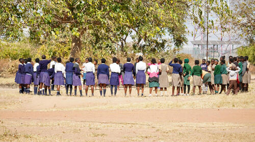 A group of girls standing outside a school.