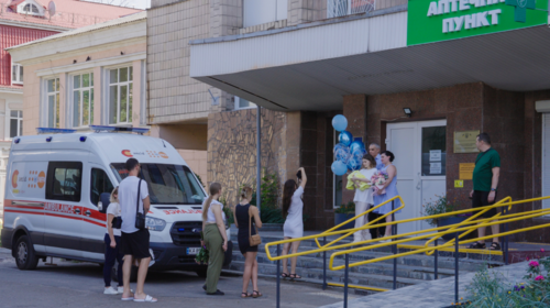 Un grupo de personas saluda a una nueva madre a las puertas de un hospital